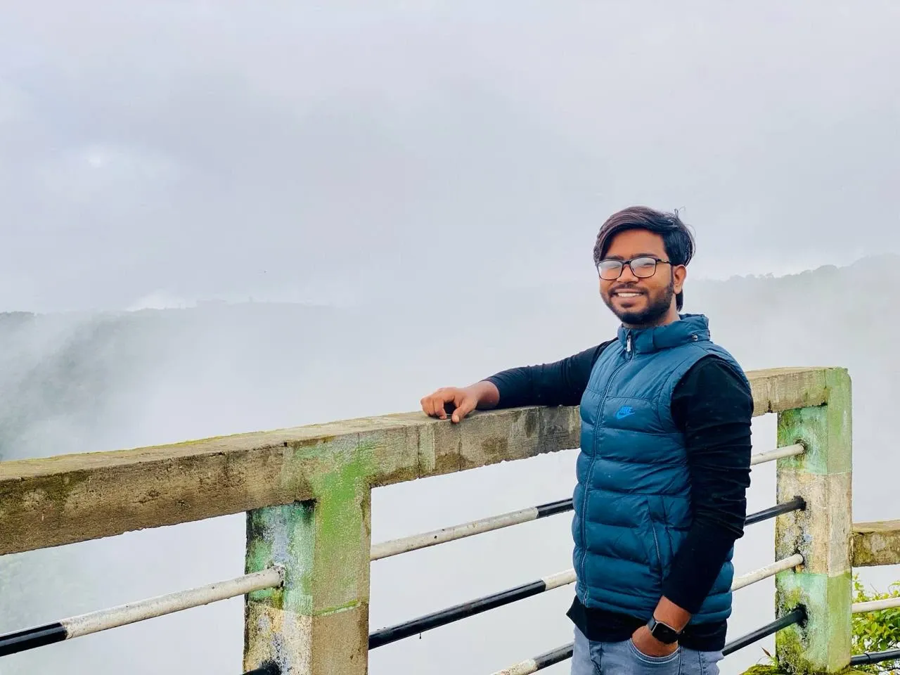 Nazir Himel smiling at a misty mountain viewpoint